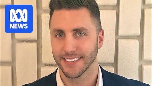 A man, smiling, wearing a suit.