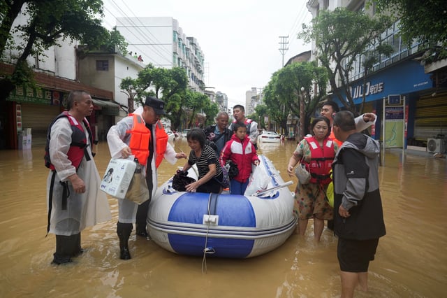 Rescue workers evacuate flood-affected residents with a boat in Rongjiang county, Guizhou province, China June 24, 2025. China Daily via REUTERS