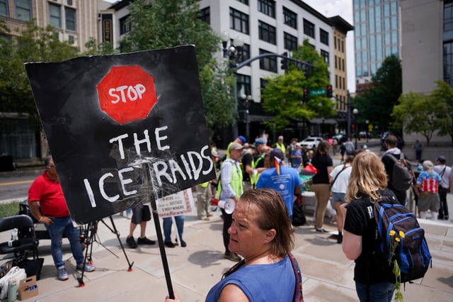 A person holds a placard as people gather for the arraignment and detention hearing for Kilmar Abrego Garcia, the man wrongly deported from Maryland to El Salvador before being returned to the United States on migrant smuggling charges, in Nashville, Tennessee, U.S., June 13, 2025. REUTERS/Seth Herald