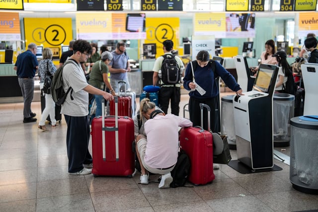 Viajeros con maletas por los pasillos de la Terminal 1 del Aeropuerto de El Prat.