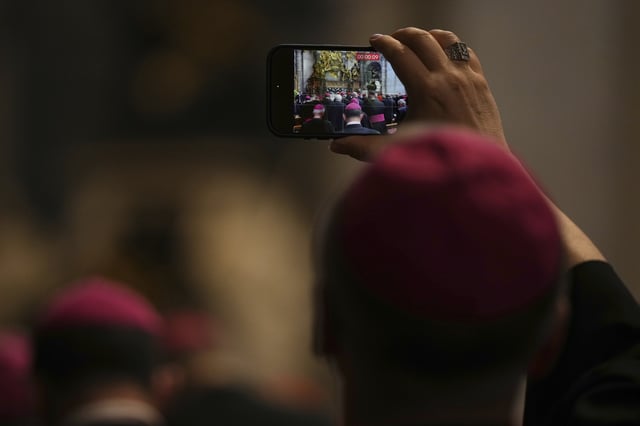 A Bishop takes photos as he attends the Pope Leo XIV leading a meditation with the participants into the Jubilee of Bishops inside St. Peter's Basilica, at the Vatican, Wednesday, June 25, 2025. (AP Photo/Andrew Medichini)