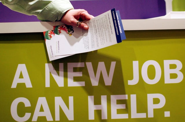 A man holds pamphlets as he waits at a job fair sponsored by employment website Monster.com in 2009. The website filed for bankruptcy 16 years later.