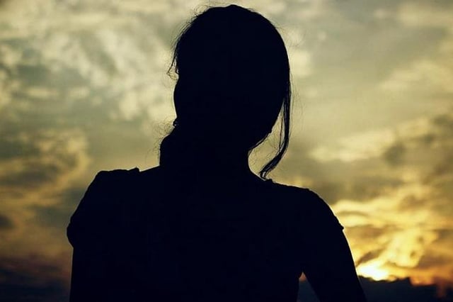 Silhoutte of a woman against the backdrop of sky 
