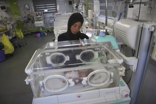 Seham Fawzy Khodeir watches her son, Hisham, who is just days old and was born prematurely, lying in an incubator at the neonatal intensive care unit of Nasser Hospital in Khan Younis, southern Gaza Strip, Thursday, June 19, 2025. (AP Photo/Mariam Dagga)