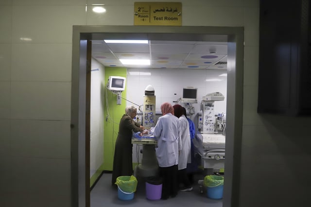 A mother watches as her prematurely born baby is examined at the neonatal intensive care unit of Nasser Hospital in Khan Younis, southern Gaza Strip, Thursday, June 19, 2025. (AP Photo/Mariam Dagga)
