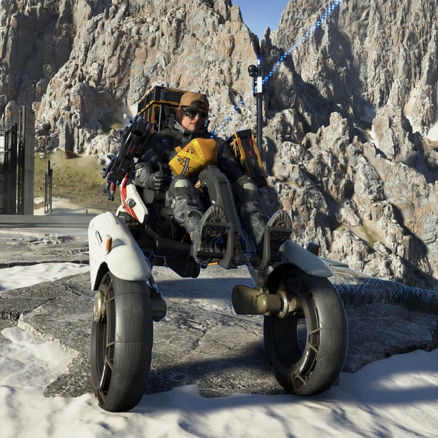 Death Stranding 2 vehicles: A head-on shot of Sam riding a Tri-Cruiser, parked outside a research facility in a mountainous area.