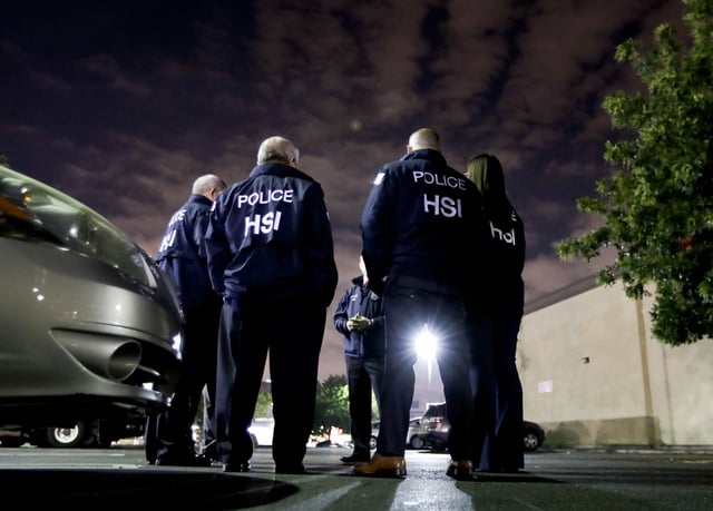 FILE - In this Jan. 10, 2018, file photo, U.S. Immigration and Customs Enforcement agents gather before serving an employment audit notice at a 7-Eleven convenience store, in Los Angeles. (AP Photo/Chris Carlson, File)