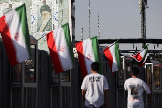 People walk near a mural of Iran's Supreme Leader, Ayatollah Ali Khamenei, amid the Iran-Israel conflict, in Tehran, Iran, June 23, 2025. Majid Asgaripour/WANA (West Asia News Agency) via REUTERS/ File Photo