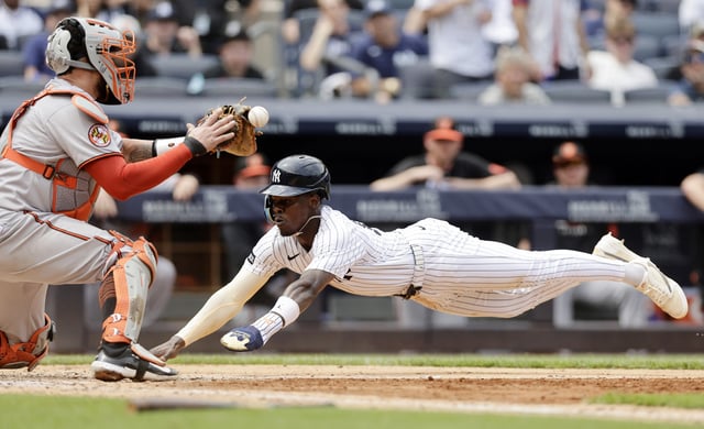 NEW YORK, NEW YORK - JUNE 22: Jazz Chisholm Jr. #13 of the New York Yankees dives home for a run during the eighth inning as Gary Sanchez #99 of the Baltimore Orioles can&#39;t hold onto the ball at Yankee Stadium on June 22, 2025 in New York City.