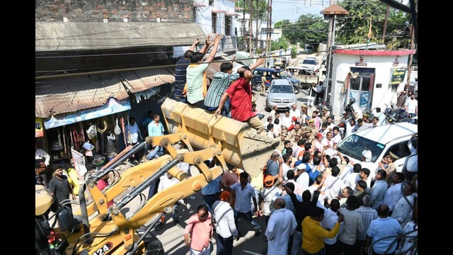 BJP workers on a JCB block the route of an SP delegation in Gorakhpur on Wednesday (HT Photo)