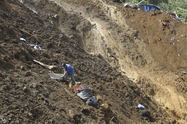 A man collects belongings after a deadly landslide was triggered by heavy rain in Bello, Antioquia state, Colombia, Wednesday, June 25, 2025. (AP Photo/Fredy Amariles)