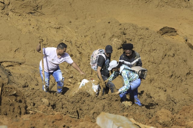 Residents collect belongings after a deadly landslide was triggered by heavy rain in Bello, Antioquia state, Colombia, Wednesday, June 25, 2025. (AP Photo/Fredy Amariles)