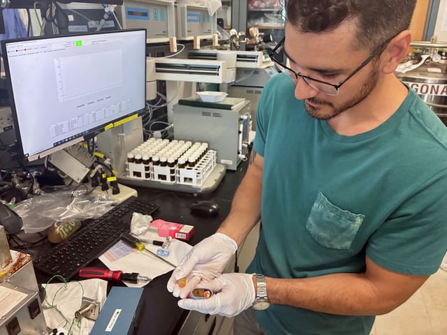 UC Davis researcher Mark Salazar in a lab with disposable vape pods. Their study found some disposable vapes emit more toxic metals — including lead and nickel — than traditional cigarettes.