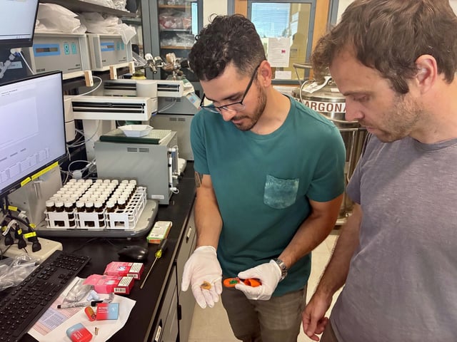 UC Davis researchers Mark Salazar (left) and Brett Poulin in a lab with disposable vape pods. Their study found some disposable vapes emit more toxic metals — including lead and nickel — than traditional cigarettes.