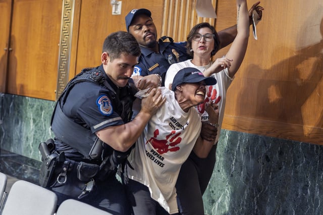 U.S. Capitol Police remove protesters after they began shouting in a Senate Appropriations Committee hearing as Office of Management and Budget director Russell Vought began to testify on the rescissions package, at the Capitol in Washington, Wednesday, June 25, 2025. (AP Photo/J. Scott Applewhite)