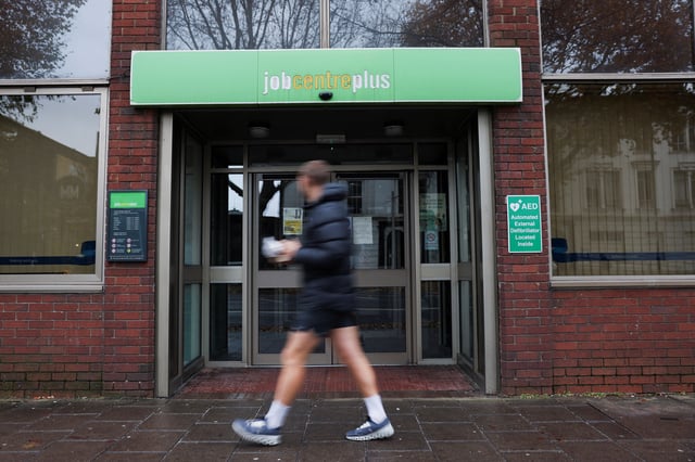 A passer-by walks past a job centre in Borough, in London, Britain, December 1, 2024. REUTERS/Mina Kim/File photo