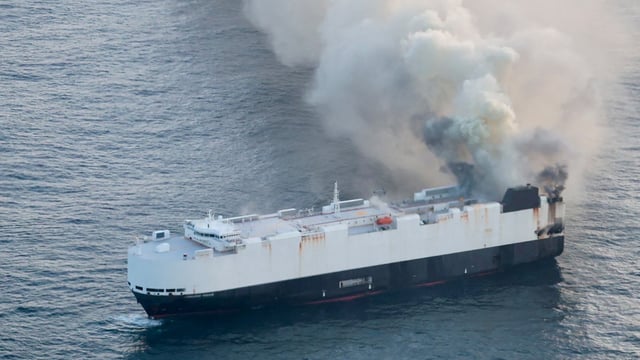 Smoke rises from a fire aboard the cargo vessel Morning Midas, carrying around 3,000 vehicles, including 800 electric vehicles