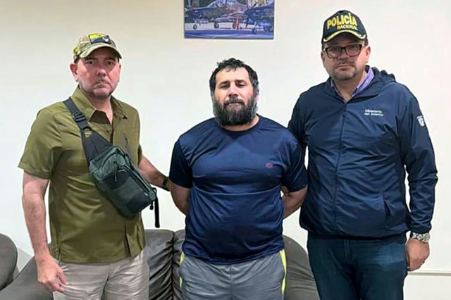 Sur cette photo diffusée par l'armée équatorienne, Adolfo Macias, alias "Fito" (centre), est entouré du ministre de la Défense Carlo Loffredo (gauche) et du ministre de l'Intérieur John Reimberg, le 25 juin 2025 à Manta (Equateur)