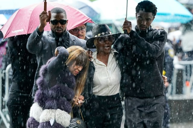 King Combs (d), fils de P. Didddy (Sean Combs), tient un parapluie pour Janice Combs, la mère du rappeur visé par un procès, alors qu'ils arrivent au tribunal fédéral à New York, le 14 mai 2025