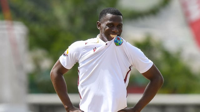 Shamar Joseph of West Indies bites his shirt and smiles during the first day of the 1st test match against Australia at Kensington Oval, Bridgetown, Barbados