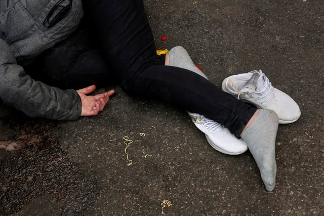 A man who has passed out lies in a parking lot in the Kensington area of Philadelphia, Pennsylvania, U.S., March 26, 2025. REUTERS/Shannon Stapleton/File Photo
