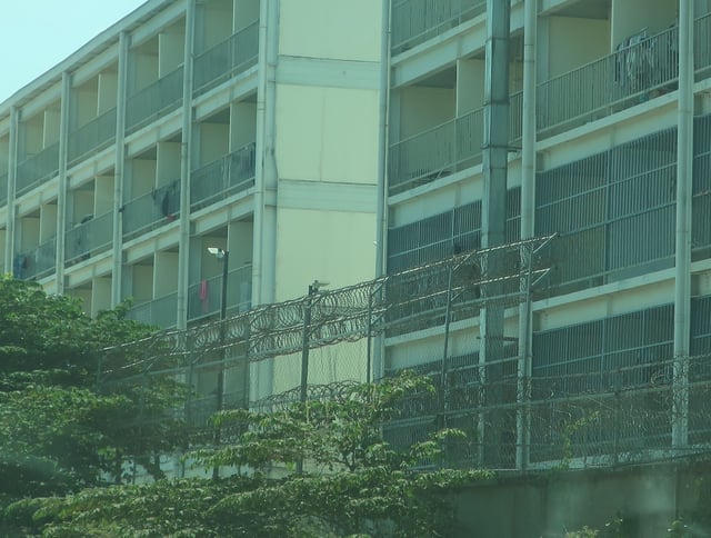 Eastern perimeter wall of a scamming compound in Phnom Penh that is heightened and angled towards the interior with barbed or razor wire on the inside to prevent climbing. © Amnesty International, 2024.