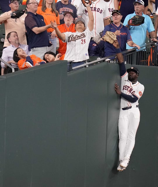 Houston Astros left fielder Taylor Trammell (26) tries to catch Philadelphia Phillies&#39; Edmundo Sosa&#39;s foul ball against the wall during the seventh inning of a baseball game, Wednesday, June 25, 2025, in Houston. (AP Photo/Karen Warren)