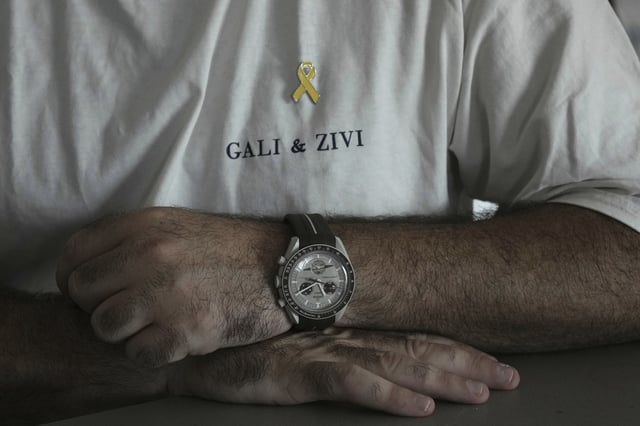 Liran Berman, brother of twins Ziv and Gali Berman, who were abducted by militants on Oct. 7, 2023, wears a T-shirt with their names in Or Akiva, Israel, Wednesday, June 25, 2025. (AP Photo/Maya Alleruzzo)