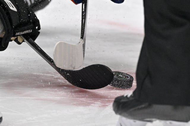 Feb 26, 2024; Dallas, Texas, USA; A view of the face-off circle and an NHL puck and the Dallas Stars logo and hockey sticks during a face-off in the third period of the game between the Dallas Stars and the New York Islanders at the American Airlines Center. Mandatory Credit: Jerome Miron-USA TODAY Sports/File Photo