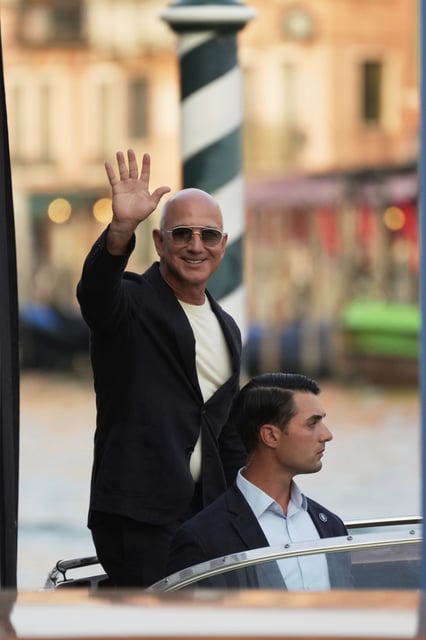Amazon multi-billionaire founder Jeff Bezos waves as he leaves by boat an hotel in Venice, Italy, on Wednesday, June 25, 2025, ahead of festivities in the lagoon city reportedly linked to his wedding with Lauren Sanchez. (AP Photo/Luca Bruno)