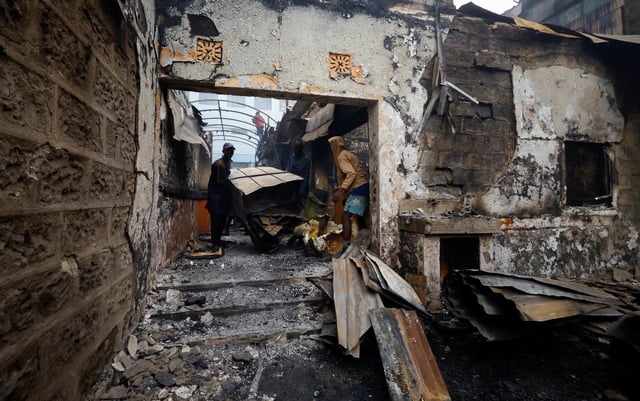People salvage steel from buildings torched during demonstrations to mark the first anniversary of the deadly 2024 anti-government protests that drew widespread condemnation over the use of force by security agencies, in downtown Nairobi, Kenya June 26, 2025. REUTERS/Thomas Mukoya