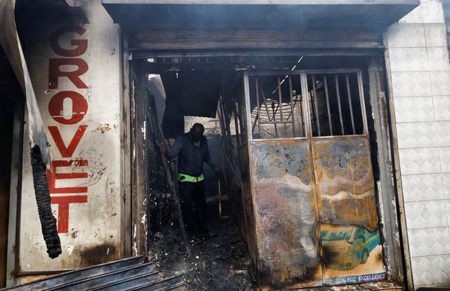 A man salvages steel from an agrovet store torched during demonstrations to mark the first anniversary of the deadly 2024 anti-government protests that drew widespread condemnation over the use of force by security agencies, in downtown Nairobi, Kenya June 26, 2025. REUTERS/Thomas Mukoya