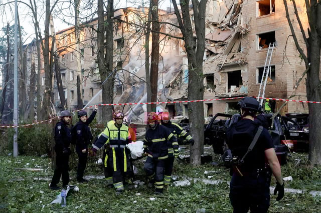 Emergency Service personnel carry a body following Russian strikes on Kyiv on June 23.