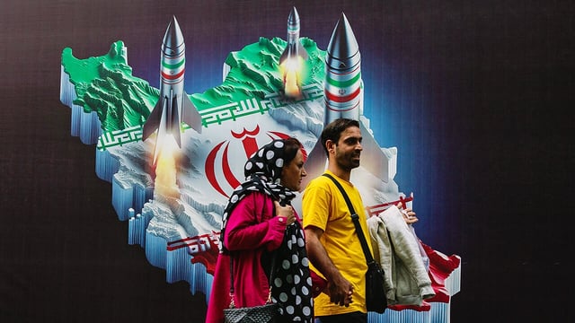 People walk past a mural depicting Iranian missiles in Tehran, Iran