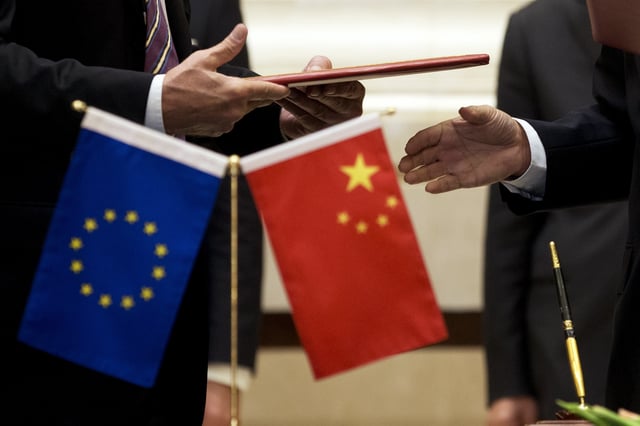 FILE - A member of European Commission, left, prepares to exchange documents with Chinese delegation at a signing ceremony after the 5th China-EU High Level Economic and Trade dialogue at Diaoyutai State Guest House in Beijing, on Sept. 28, 2015. (AP Photo/Andy Wong, File)