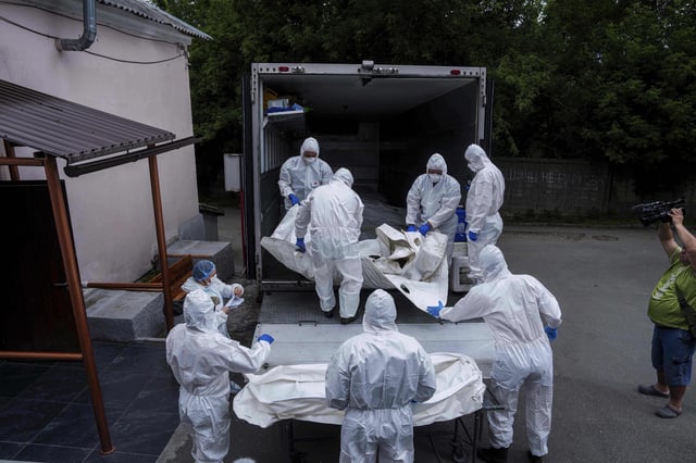 Ukrainian servicemen carry a body of their comrade repatriated from Russia, at the morgue in Kyiv, Ukraine, on Thursday, June 26, 2025. (AP Photo/Evgeniy Maloletka)