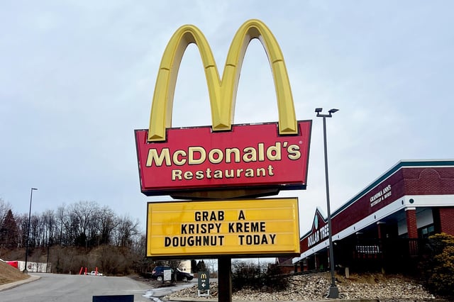 FILE- McDonald&#39;s sign advertising Krispy Kreme Doughnuts for sale. McDonald&#39;s formed a partnership with Krispy Kreme in 2024 to sell their doughnuts.