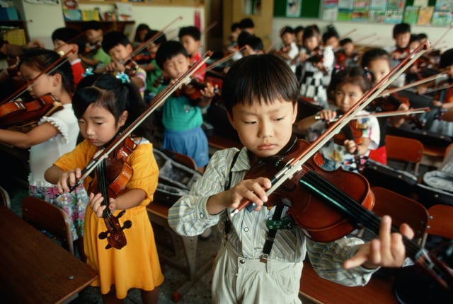 Schoolchildren practice the violin in a classroom at Son Shin Elementary School in Seoul, South Korea.