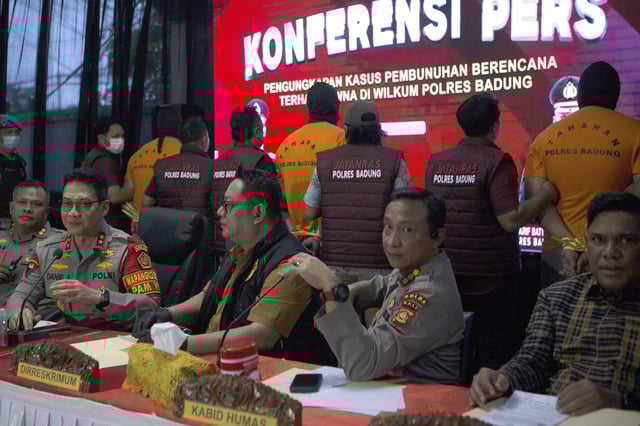 Background, from left, in orange t-shirt, Australians T.P, D.J.F, and M.C., the suspects in the murder of an Australian tourist who was shot to death at a villa, are presented to the media during a press conference at the local police precinct in Badung, Bali, Indonesia on Thursday, June 26, 2025. (AP Photo/Firdia Lisnawati)