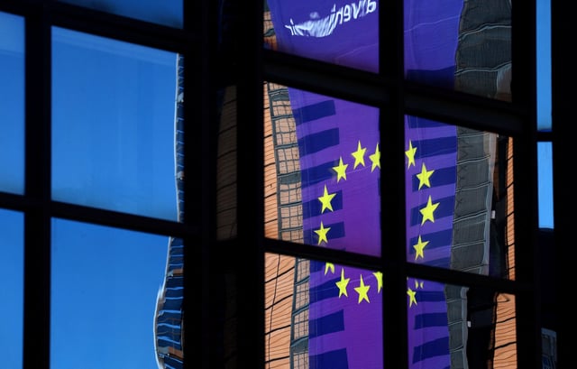 A banner depicting an European Union flag is reflected in a window outside the EU Council headquarters in Brussels, Belgium March 18, 2025. REUTERS/Yves Herman/ File Photo