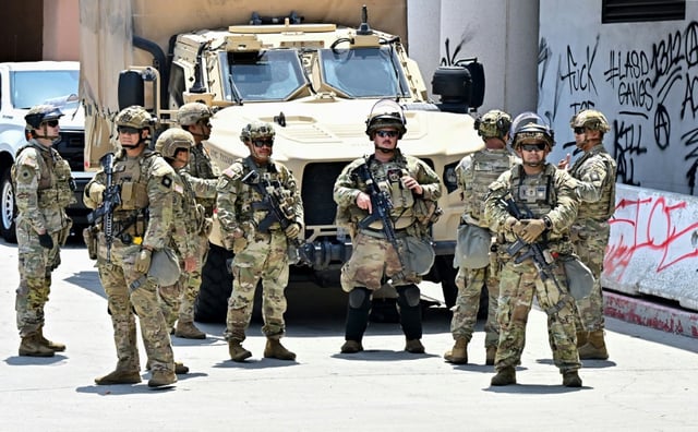 Armed members of the National Guard outside the Edward Roybal Federal Building, with graffiti visible after recent protests against immigration raids, in Los Angeles on June 23, 2025