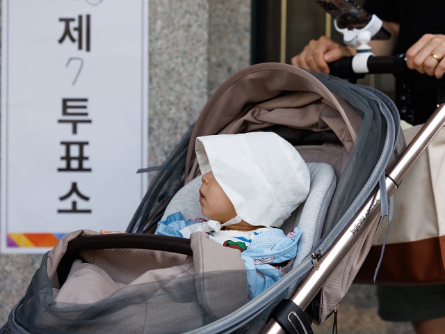 An infant in a stroller in the line at a polling station during the presidential election in Seoul, South Korea, on Tuesday, June 3, 2025. South Koreans head to the polls Tuesday to elect a new president after an attempt to impose martial law at the end of last year triggered its worst constitutional crisis in decades. Photographer: SeongJoon Cho/Bloomberg via Getty Images