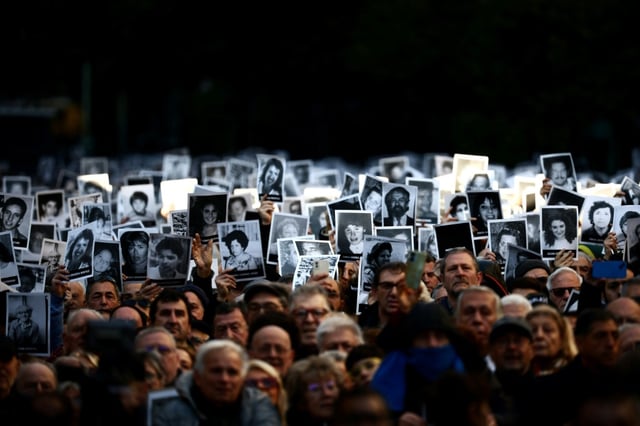 Des personnes tiennent des photos de victimes lors d'une cérémonie commémorant l'anniversaire de l'attentat à la bombe contre l'Association Mutuelle Israélite Argentine (AMIA) à Buenos Aires, le 18 juillet 2024