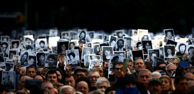 Des personnes tiennent des photos de victimes lors d'une cérémonie commémorant l'anniversaire de l'attentat à la bombe contre l'Association Mutuelle Israélite Argentine (AMIA) à Buenos Aires, le 18 juillet 2024