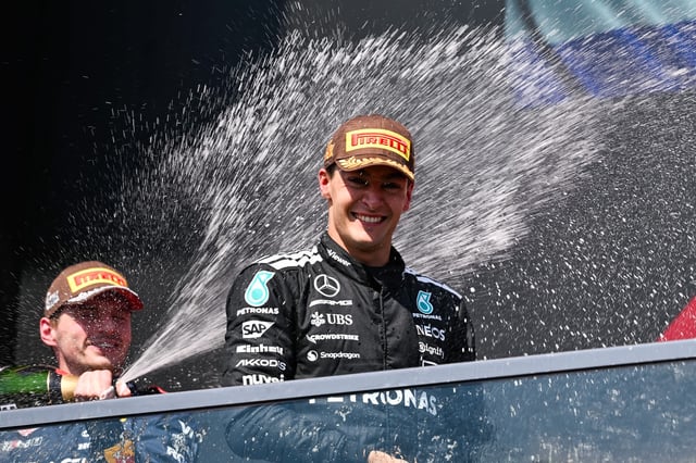 Jun 15, 2025; Montreal, Quebec, Canada; Second place Red Bull Racing driver Max Verstappen (1) sprays champagne on winner Mercedes driver George Russell (63) at Circuit Gilles-Villeneuve. Mandatory Credit: David Kirouac-Imagn Images/File Photo