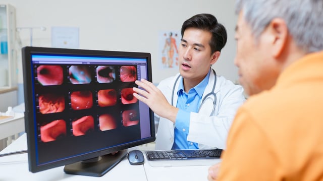 A doctor explaining the stomach cancer examination to an elderly patient.