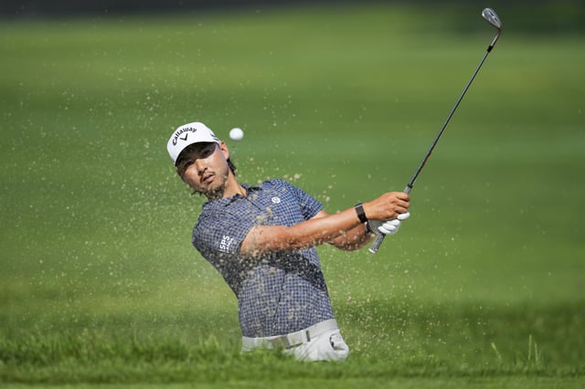 Jun 26, 2025; Detroit, Michigan, USA; Min Woo Lee plays his shot from a bunker on the second green during the first round of the Rocket Mortgage Classic golf tournament. Mandatory Credit: Aaron Doster-Imagn Images