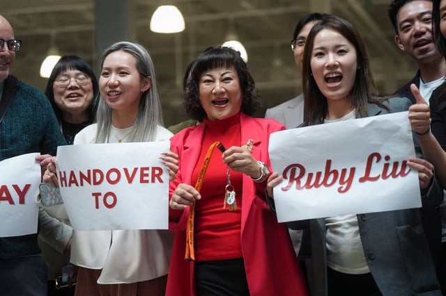 Billionaire Ruby Liu, centre, poses with her staff while holding a set of keys to a former Hudson's Bay-owned Saks off 5th department store during a "handover ceremony" at Tsawwassen Mills shopping mall that she owns, in Tsawwassen, B.C., on Thursday, June 26, 2025. Liu was granted court approval this week to take over leases for three Hudson's Bay properties in malls she owns. THE CANADIAN PRESS/Darryl Dyck