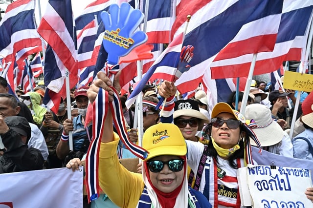 Anti-government protesters hold Thai national flags during a demonstration to demand the removal of Prime Minister Paetongtarn Shinawatra from office