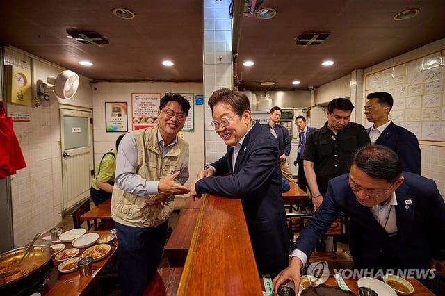 President Lee Jae Myung speaks with a citizen having lunch during his visit to a restaurant near the presidential office in Yongsan, Seoul, on June 26, 2025, in this photo provided by Lee's office. (PHOTO NOT FOR SALE) (Yonhap)